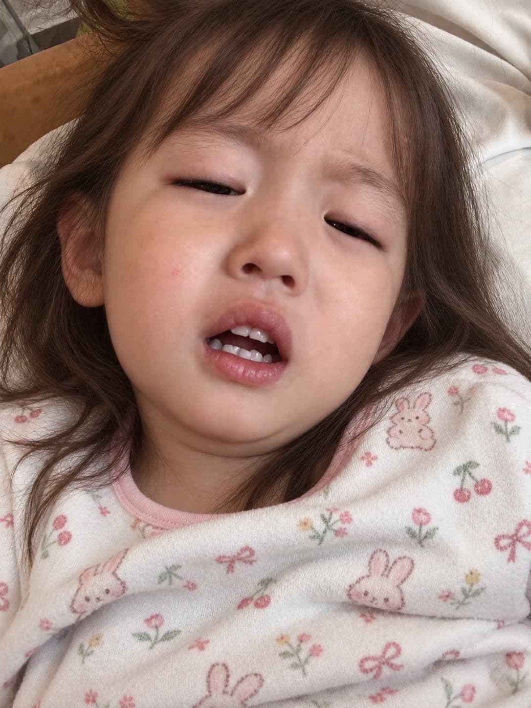 耳の不調で泣きそうな顔をしている幼い子ども
