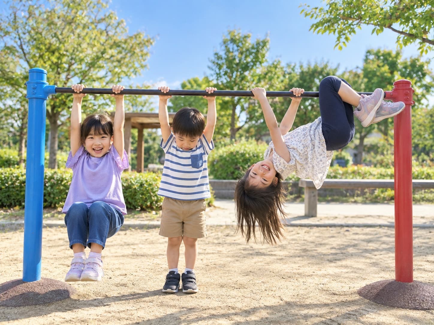 公園の鉄棒に、3人の子どもが元気にぶら下がっている様子